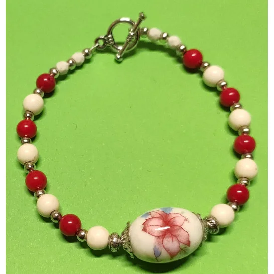 Bratara cca 20  cm , coral alb si rosu. Margele Coral sferic3 si  5,5 mm ,margele magnezit sferic fatetat, margele howlit ivori 6 mm , margele indoneziene portelan cu flori roz